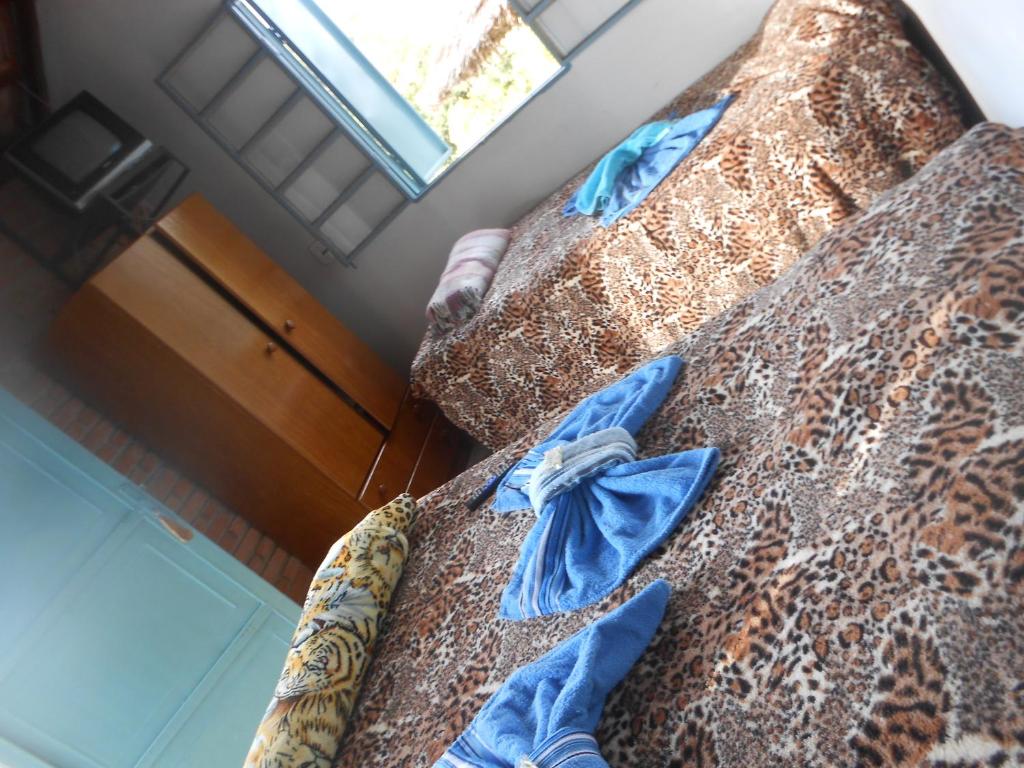2 camas en una habitación con estampado de leopardo en Pousada Shangrilá São Thomé, en São Thomé das Letras