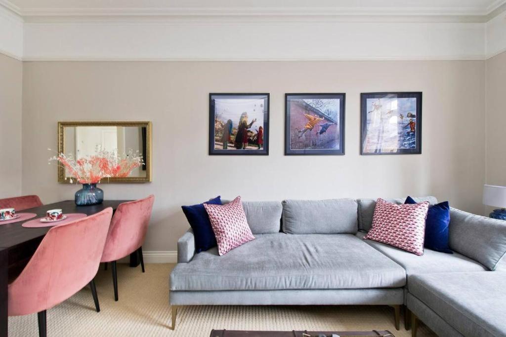 ein Wohnzimmer mit einem Sofa und einem Tisch in der Unterkunft Stylish London Getaway in the Heart of the City in London