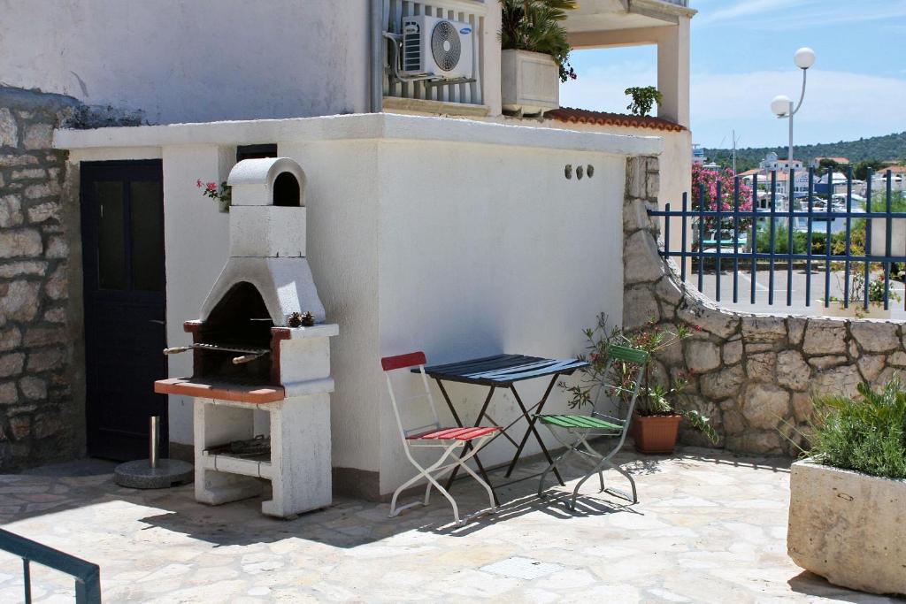 a table and chairs sitting outside of a building with a oven at Apartment Jezera 5057b in Jezera