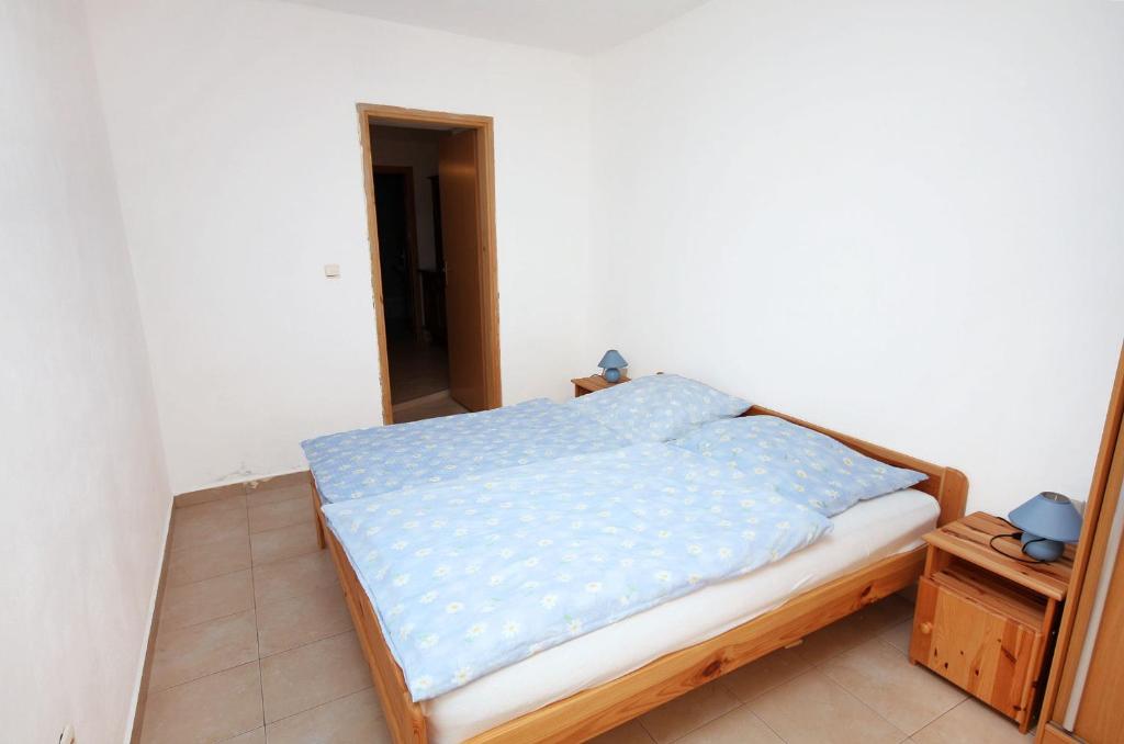 a bedroom with a bed with blue sheets on it at Apartment Jezera 5057b in Jezera