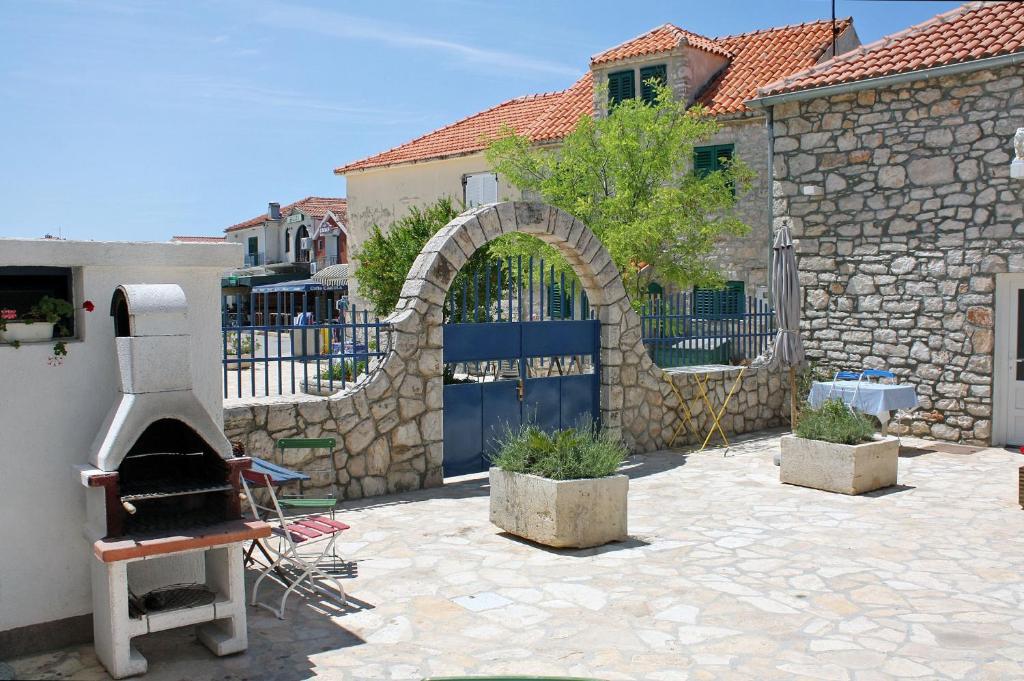an outdoor patio with a stone fence and an oven at Apartment Jezera 5057b in Jezera