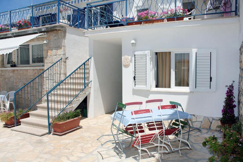 a patio with a table and chairs and a staircase at Apartment Jezera 5057b in Jezera