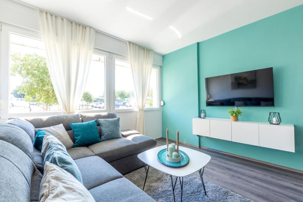 a blue living room with a couch and a tv at New Luxury Bella Apartment in Split