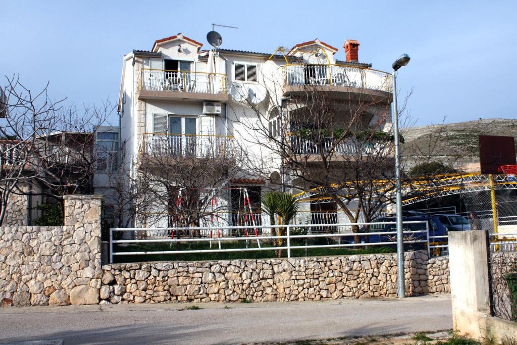 a building with two balconies on top of a stone wall at Apartment Grebastica 4867a in Grebaštica