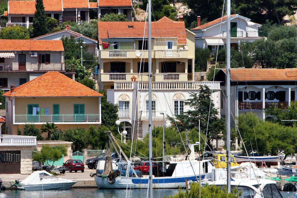a group of boats docked in a marina with houses at Apartments by the sea Jezera, Murter - 5063 in Jezera