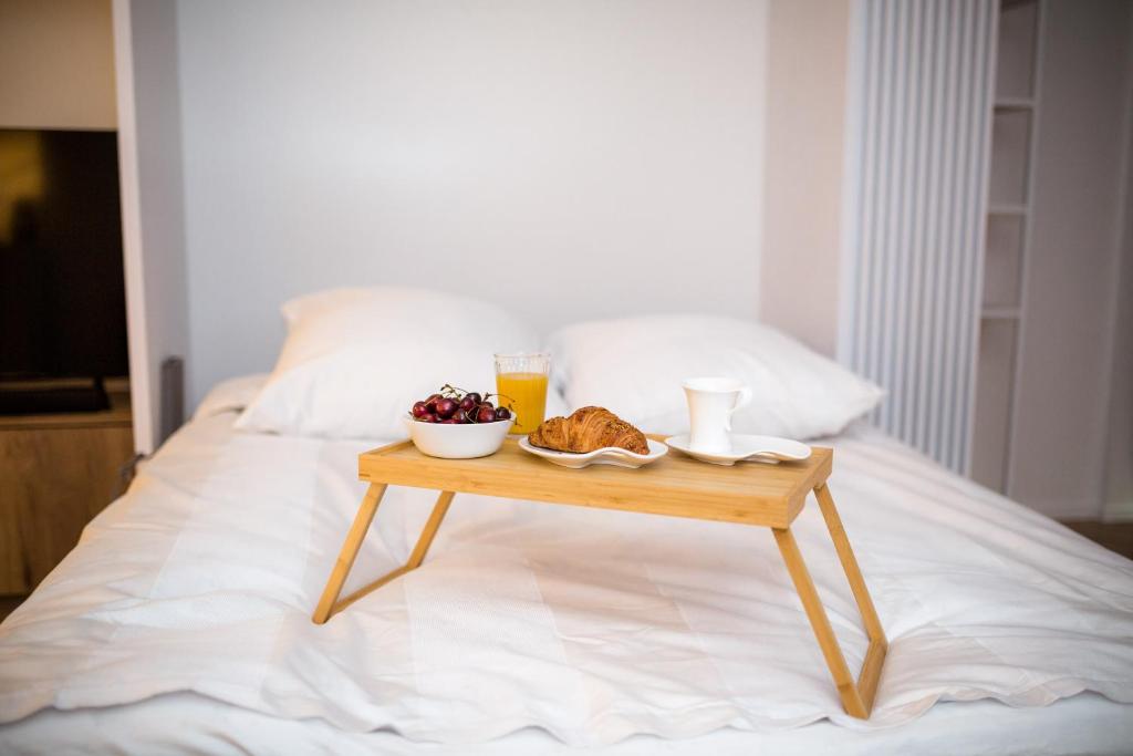 un tavolo con un vassoio di cibo su un letto di SMART Apartament typu studio BASEN & SPA Unia Residence a Lublino