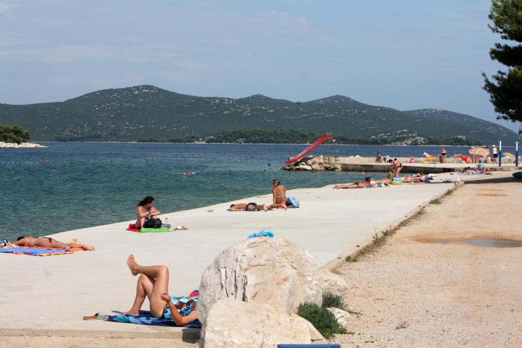 a group of people laying on a beach at Apartments by the sea Jezera, Murter - 5123 in Jezera