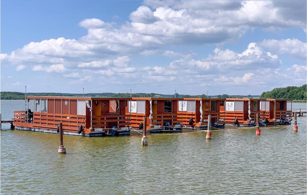 a row of houses on a boat in the water at Cozy Ship In Neuruppin With House Sea View in Neuruppin