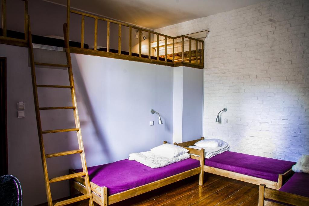 a bedroom with two bunk beds and a ladder at Angel Hostel in Toruń