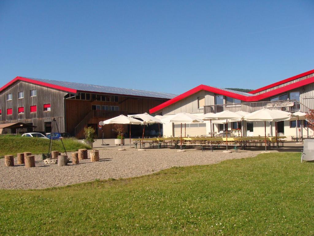 Hemishofen的住宿－博德霍夫農家樂，前面有桌子和伞的建筑
