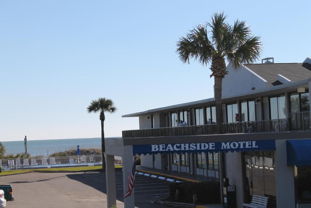 un motel junto a la playa con palmeras delante en Beachside Motel - Amelia Island, en Amelia Island