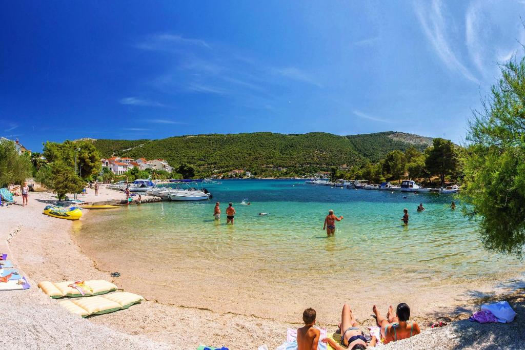 a group of people in the water at a beach at Apartments with a parking space Grebastica, Sibenik - 13365 in Bašelovići