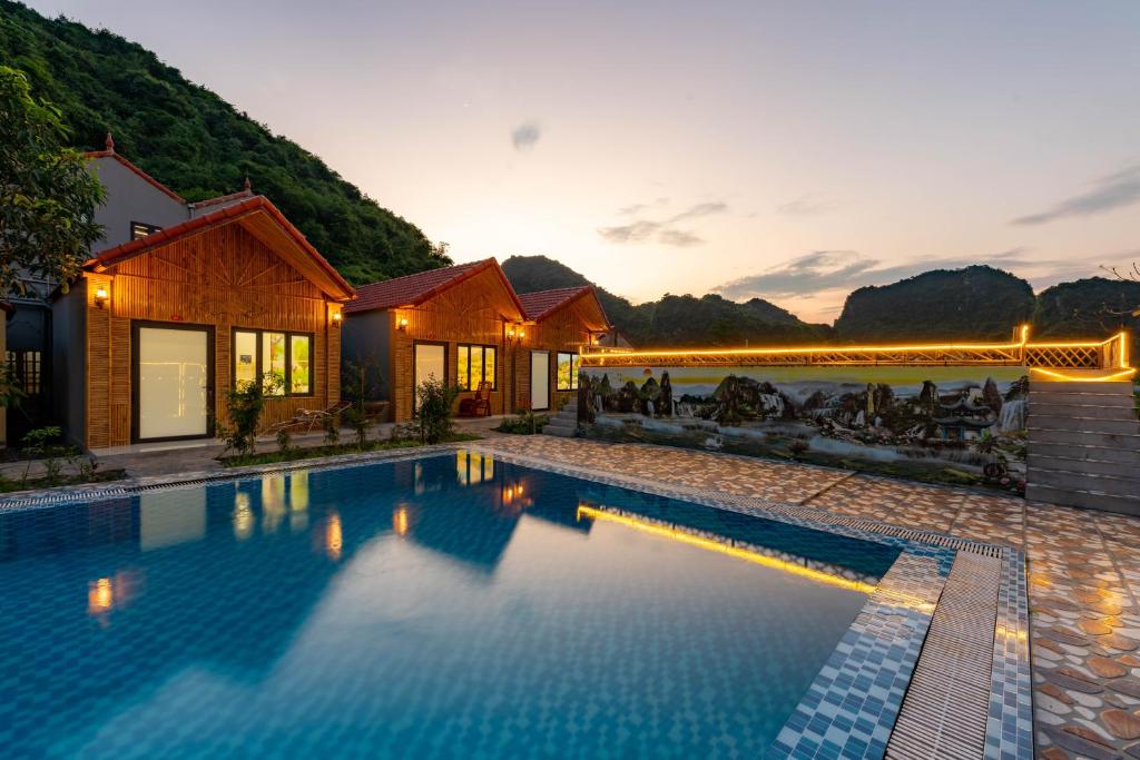 a villa with a swimming pool at sunset at Tan Dinh Farmstay in Ninh Binh