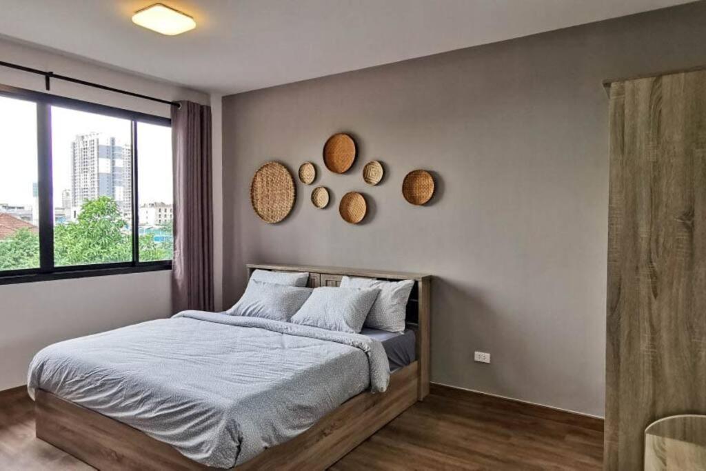 a bedroom with a bed and mirrors on the wall at 8FINITE House in Bang Su