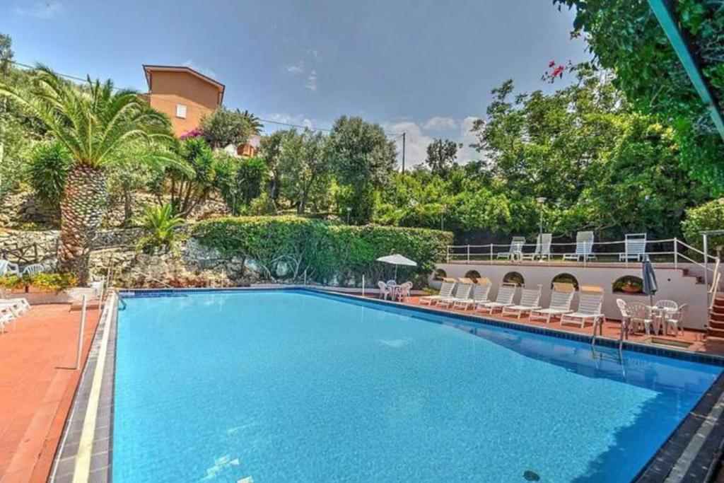 een groot zwembad met stoelen en een gebouw bij Un Paradiso a Sorrento con piscina in Massa Lubrense