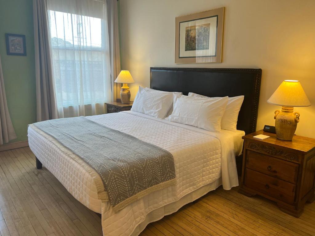 a bedroom with a large bed with white sheets and pillows at Canyon Rose Suites in Bisbee