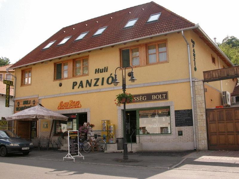 a building on the corner of a street with a store at Huli Panzio in Tokaj