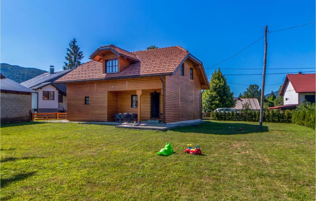 a house in a yard with a green bag on the grass at 2 Bedroom Beautiful Home In Jasenak in Jasenak