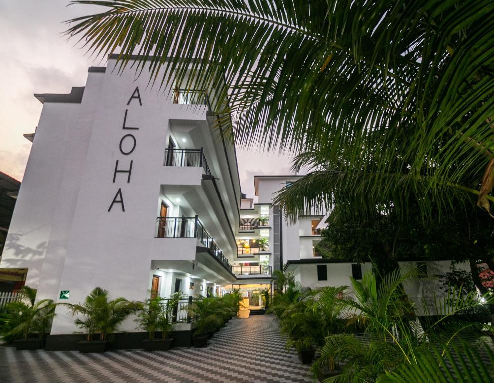 a white building with the word acropolis on it at Aloha Holiday Resort in Baga