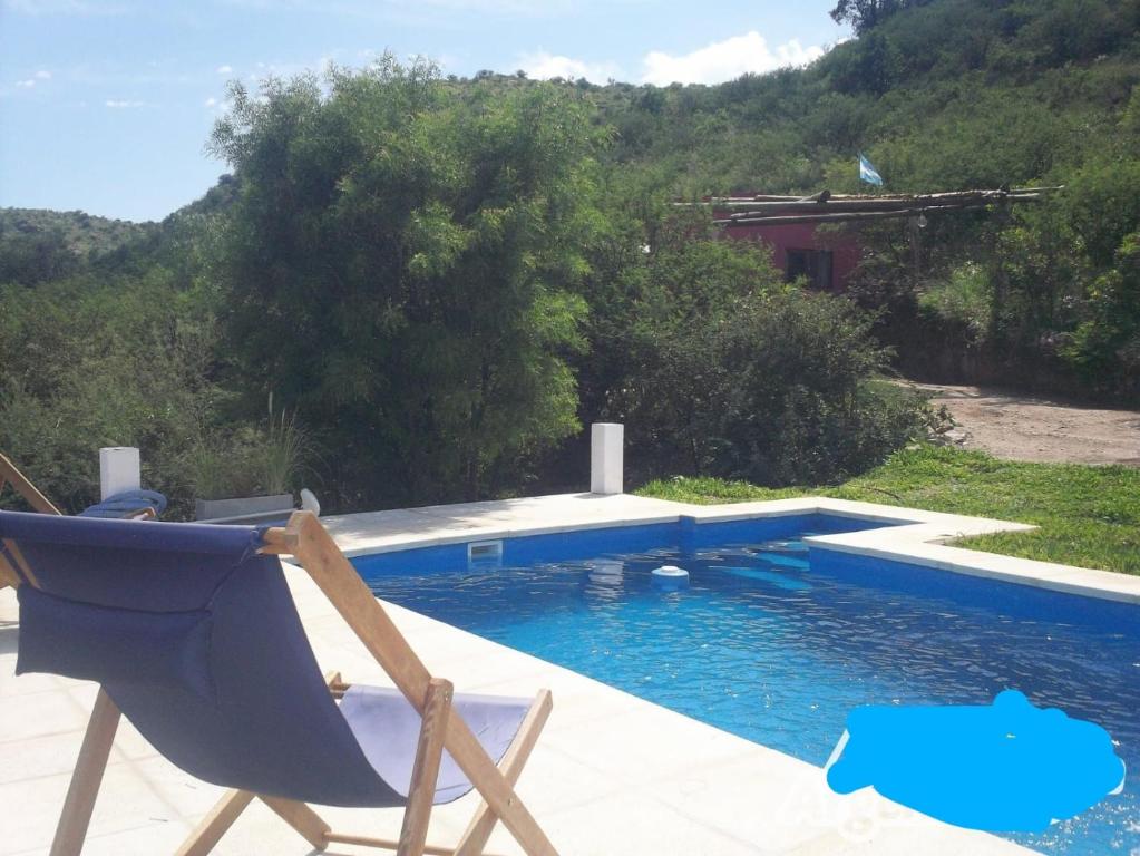 a blue chair sitting next to a swimming pool at 7 Colores Casas Serranas in San Marcos Sierras