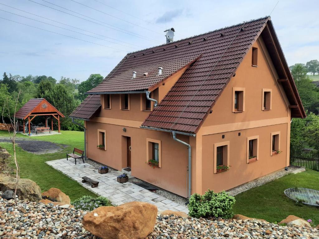 ein Haus mit einem braunen Dach und einem Hof in der Unterkunft Apartmány Studený in Kunratice