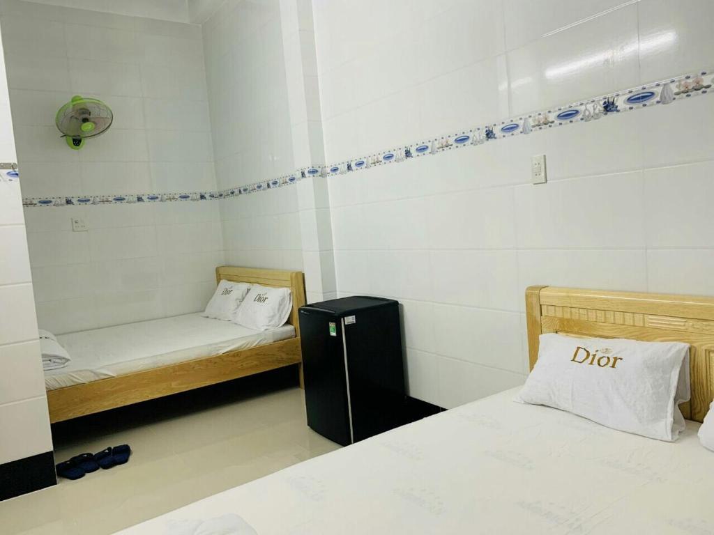 een kamer met 2 bedden en een kussen met het woord vuil bij Homestay Khánh Hưng - Đảo Phú Quý - Bình Thuận in Cu Lao Thu