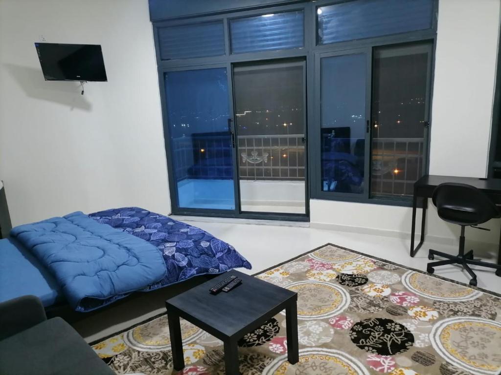 un soggiorno con letto e una grande finestra di Durrat Al Israa a Umm el ‘Amad