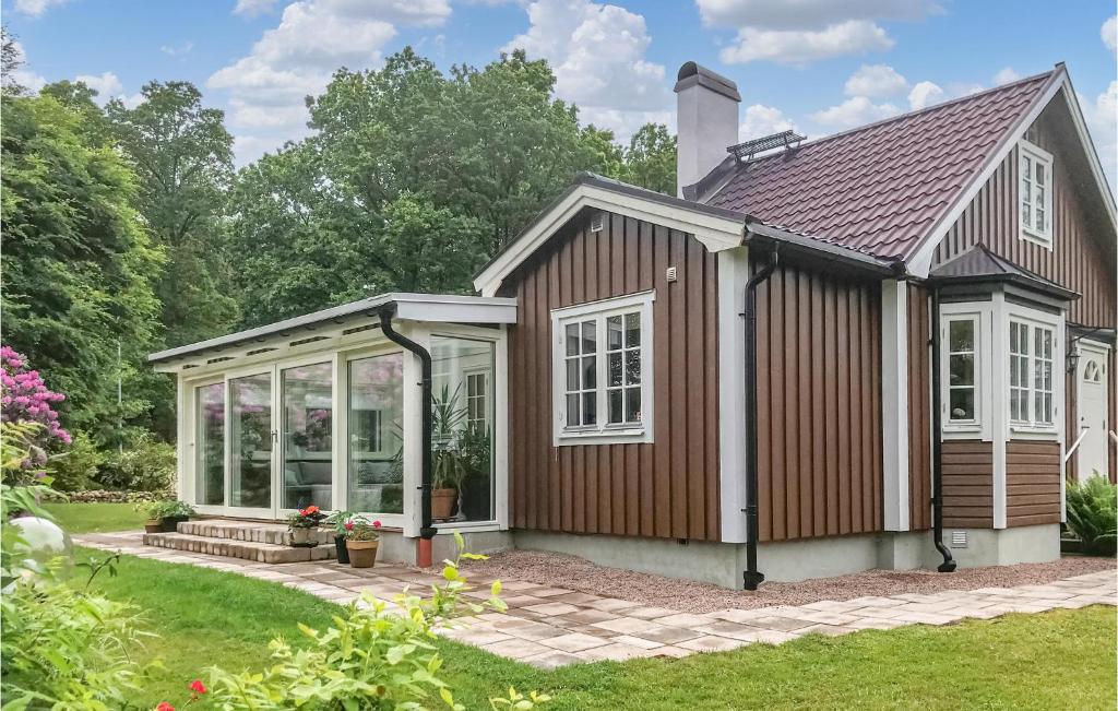 a small house with a greenhouse in a garden at Nice Home In Halmstad With Kitchen in Öppinge