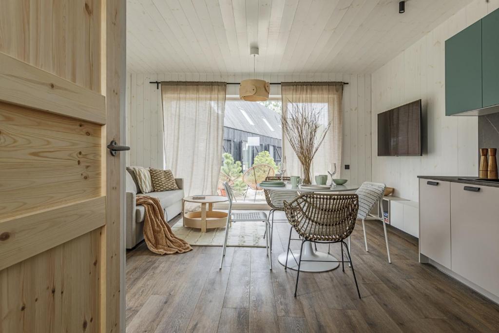 a kitchen and living room with a table and chairs at Svencelės burė 8 in Svenele