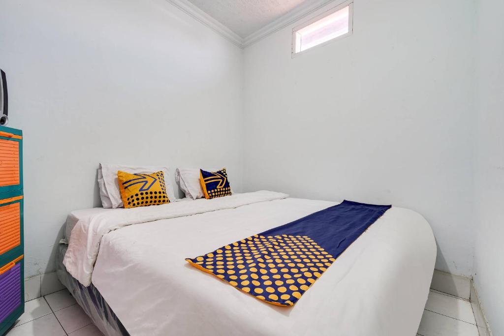 una camera bianca con un letto con cuscini sopra di SPOT ON 91386 De Jawara Homestay Syariah a Cilimus 2