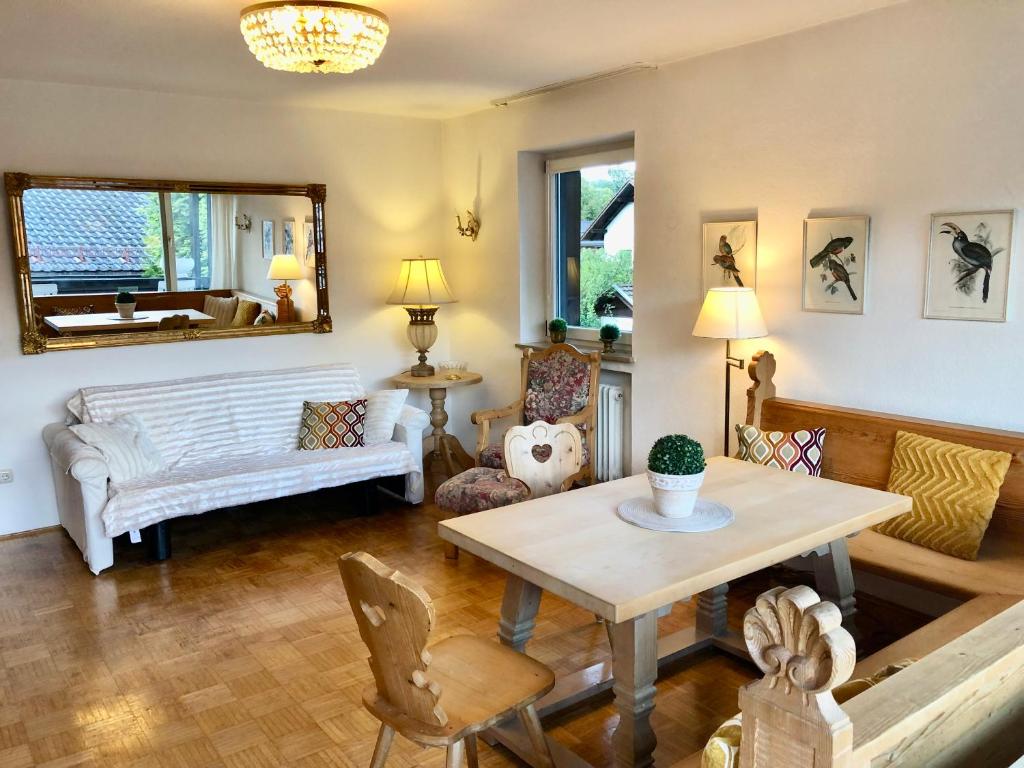 ein Wohnzimmer mit einem Tisch und einem Sofa in der Unterkunft Landhaus Alpenblick in Garmisch-Partenkirchen