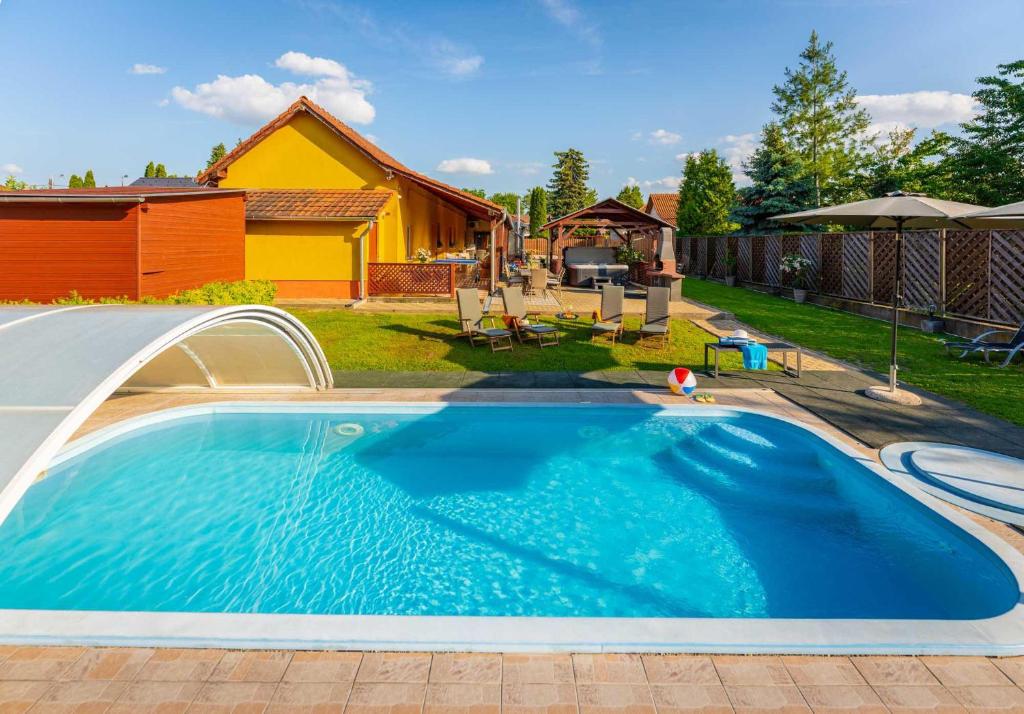 una piscina en un patio con una casa en Fiesta Balaton Villa, en Balatonszárszó