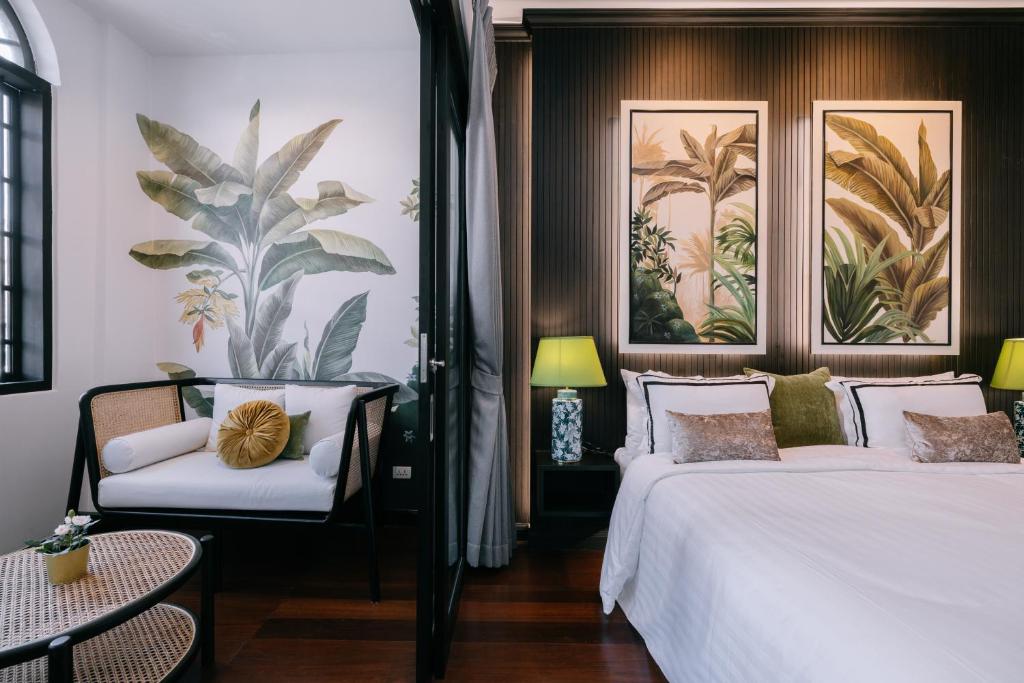 um quarto de hotel com duas camas e uma cadeira em BAAN 125 STAY Phuket em Phuket