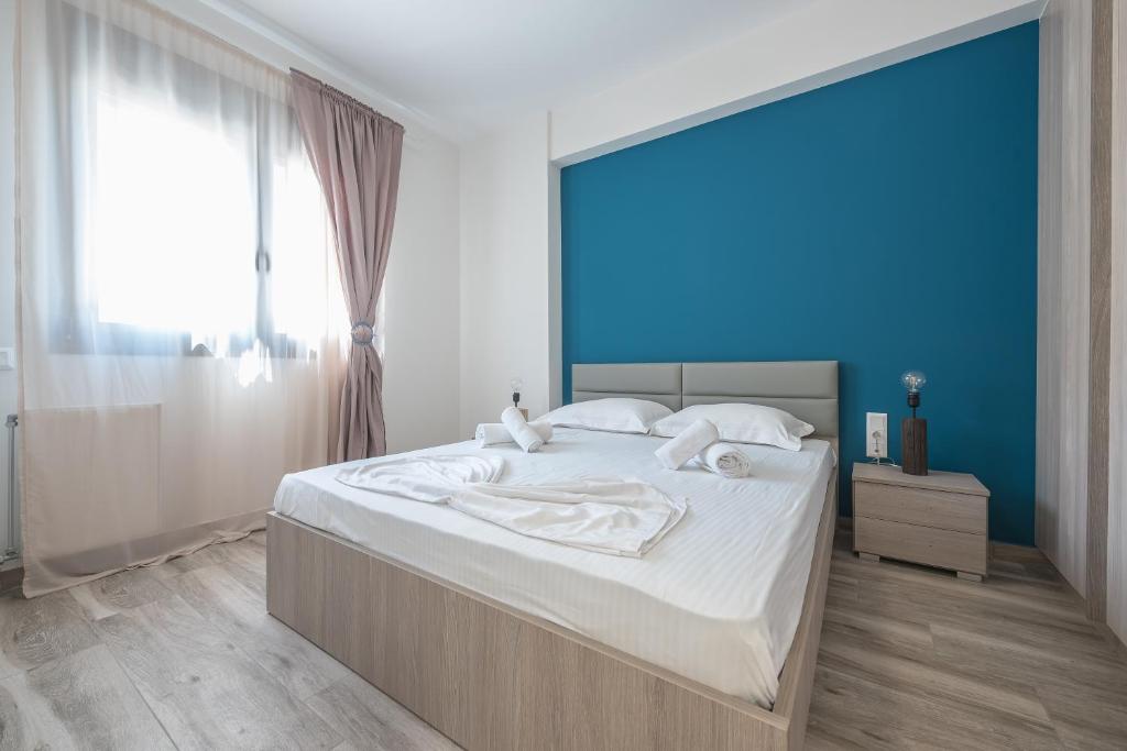 1 dormitorio con 1 cama grande y pared azul en Newly renovated apt in the heart of Kerameikos, en Atenas