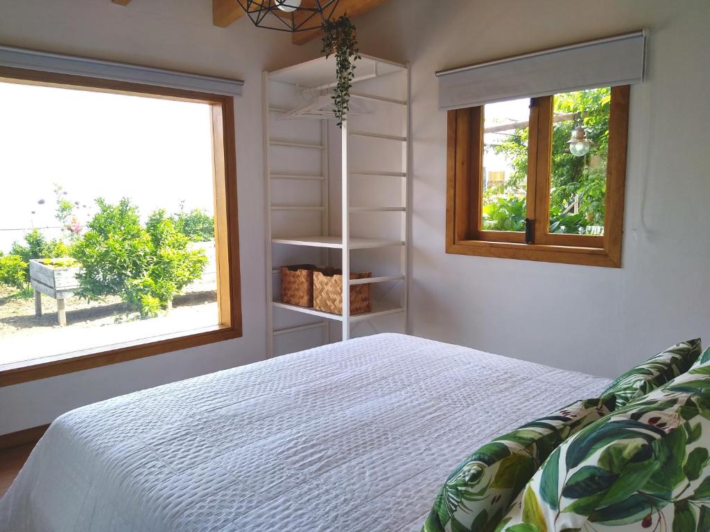 a bedroom with a white bed and a window at Los Huertos Conect with the nature & relax in Icod de los Vinos