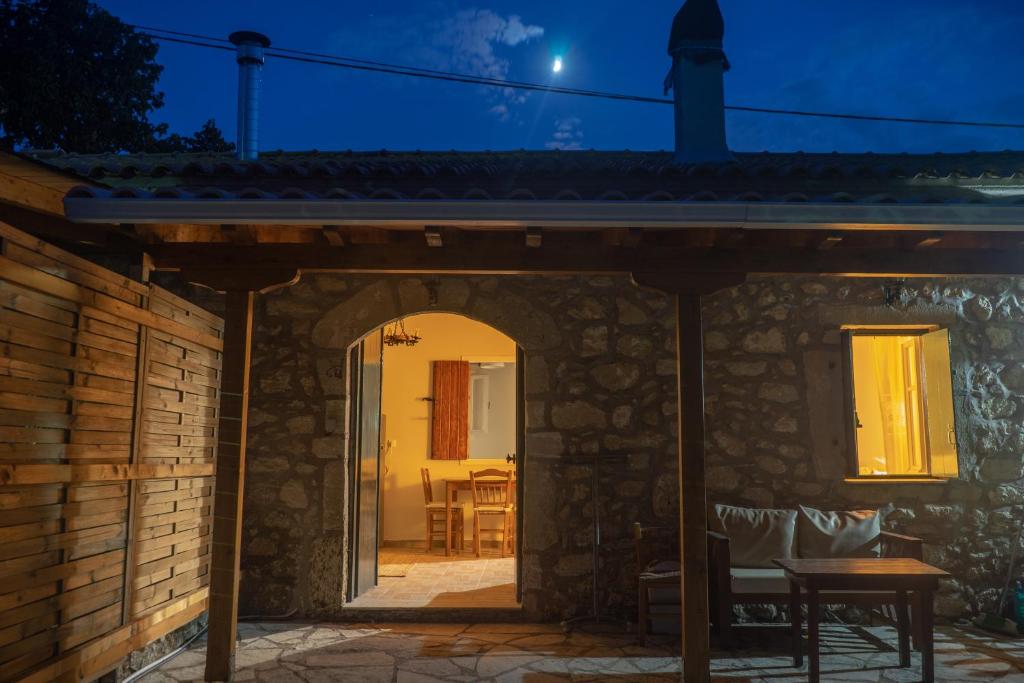 a stone house with a patio at night at Kantounia Stonehouse in Vavkerí