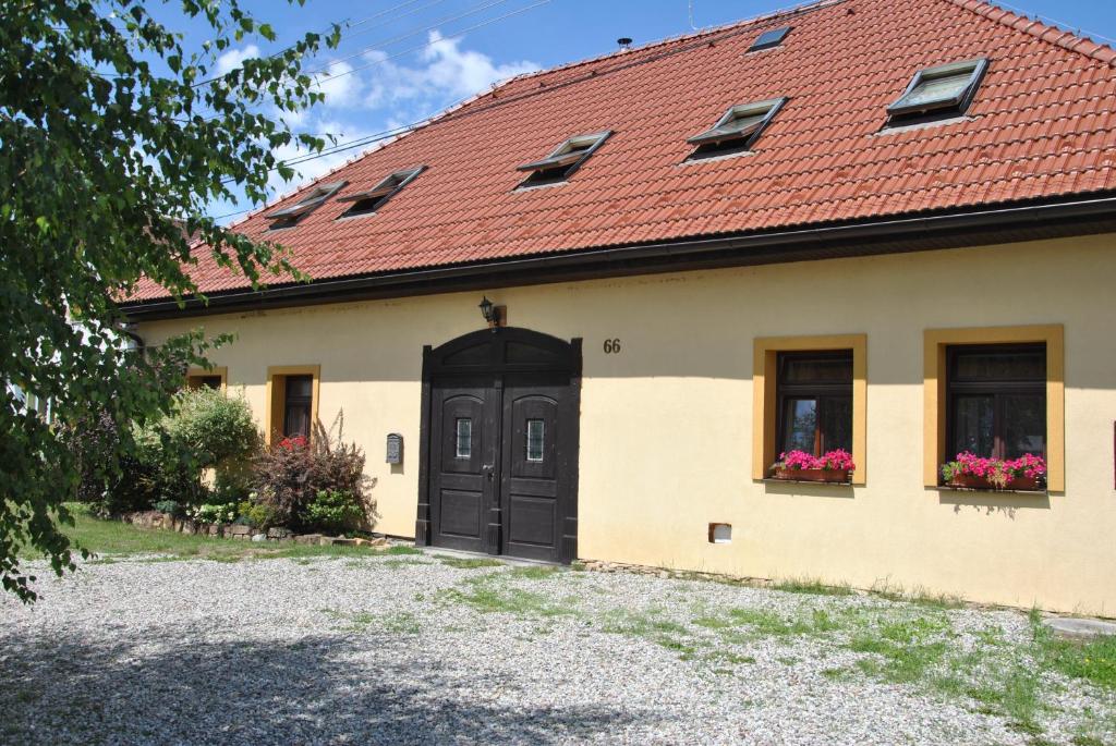 a house with a red roof and a black door at Privat 66 in Liptovský Trnovec