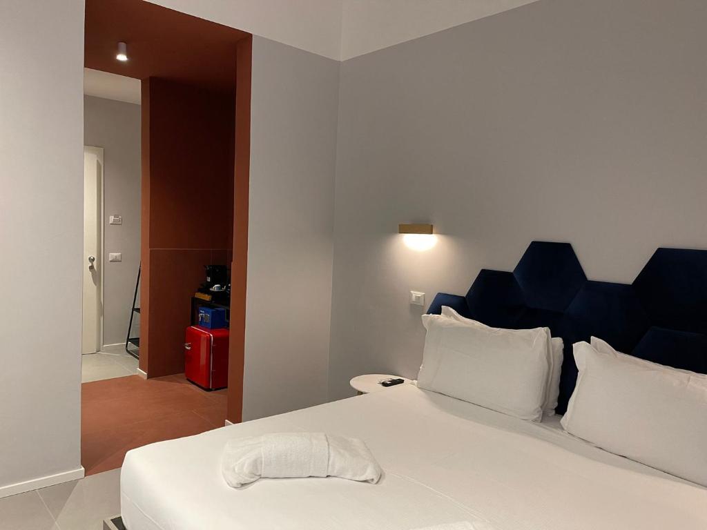 a bedroom with a large white bed with a blue headboard at Carrara 24 in Rome