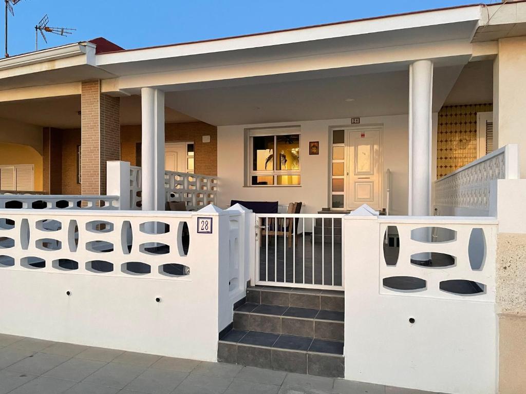 una casa con cancelli bianchi e un portico di Chalet Playa Miramar a Miramar