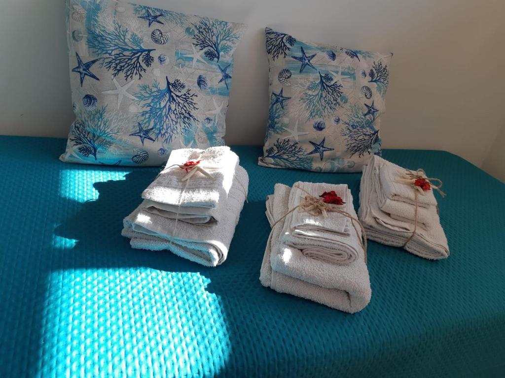 - un ensemble de serviettes sur un lit avec des oreillers dans l'établissement Tramonti d'estate - Casa Vacanze, à Ortona