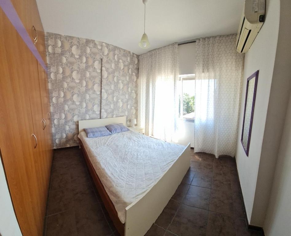 um quarto com uma cama e uma grande janela em 1bedroom flat next to papas em Limassol