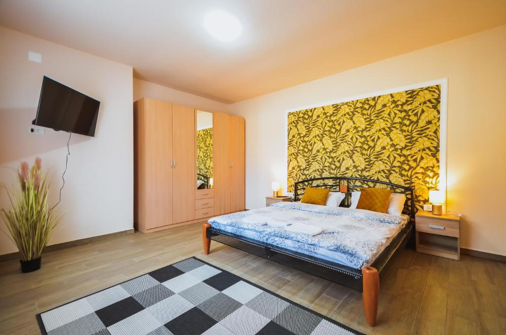 a bedroom with a bed with a yellow wall at Hera's Garden in Arad