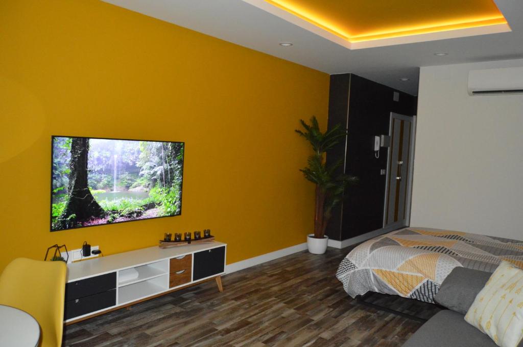 a bedroom with a tv on a yellow wall at DIAMOND TORREMOLINOS TROPICAL in Torremolinos
