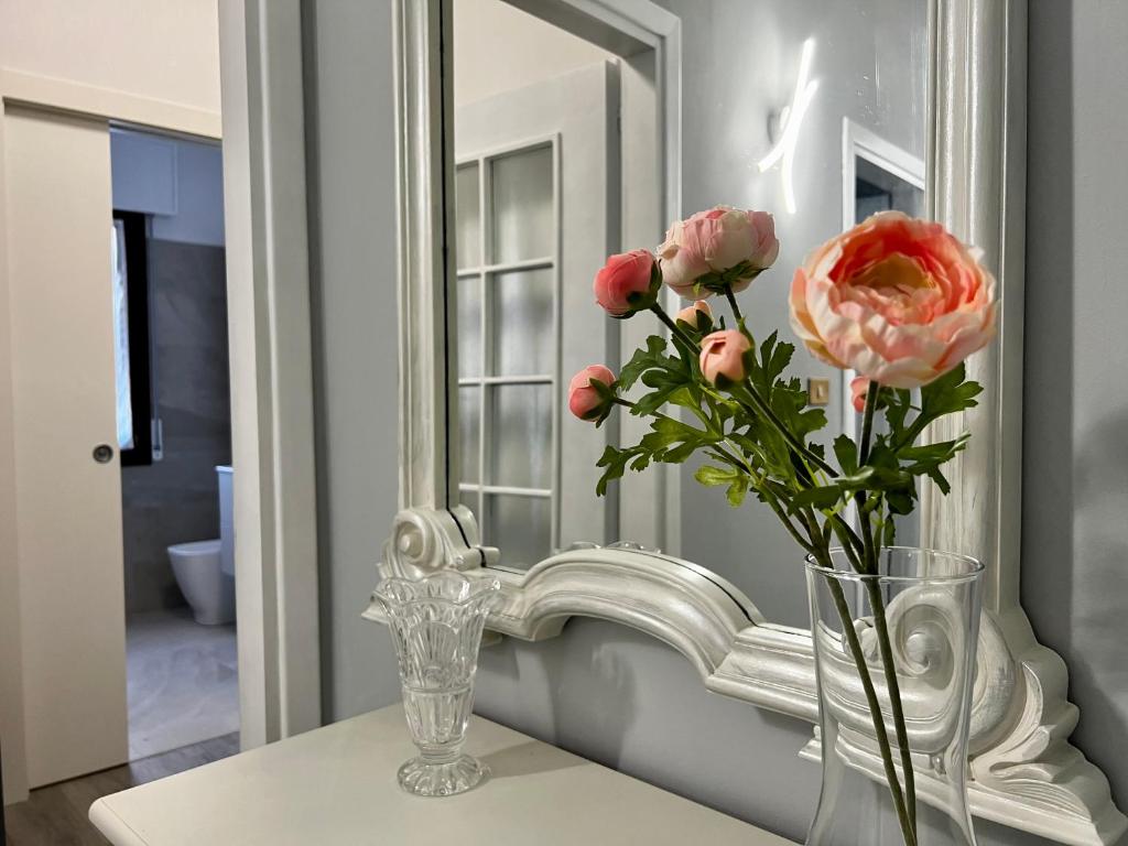 un jarrón de flores en una mesa frente a un espejo en Interno1 en Mestre
