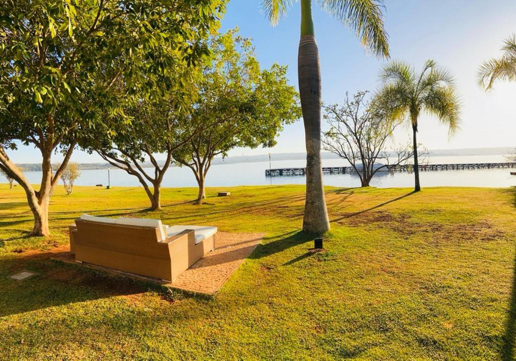 a bench in a park next to a palm tree at Life Resort - 2 quartos, 2 banheiros in Brasilia
