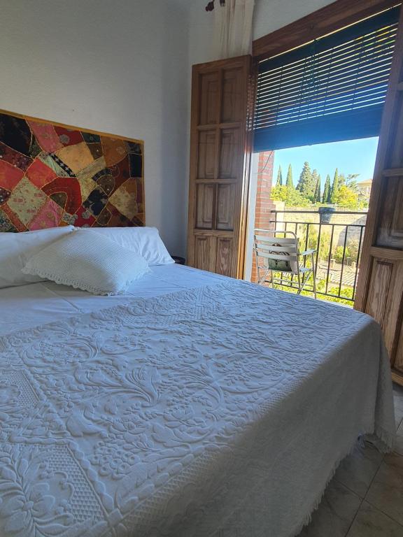 a bedroom with a bed with a view of a balcony at Carmen de la Sultana in Granada