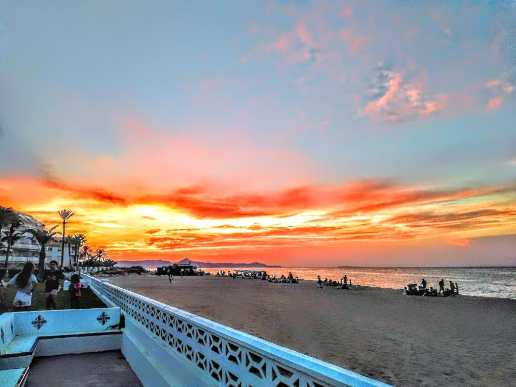 a view of a beach with a sunset at LA NARANJA DENIA 1ªlinea de playa -Wifi- Parking free in Denia