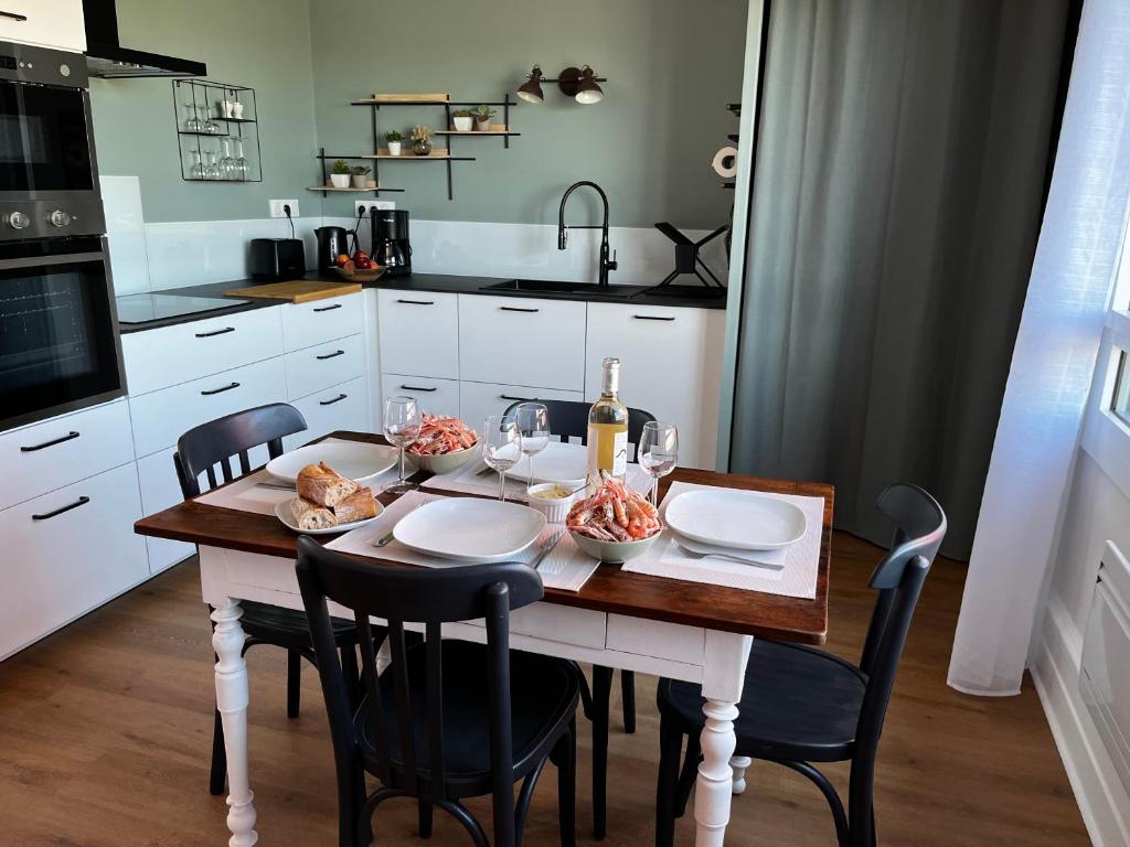 una cucina con tavolo e cibo di Lostendro, appartements vue port a Le Guilvinec