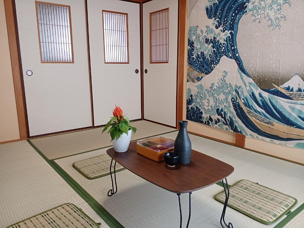una habitación con una mesa y una pintura grande en 白浜 Mizuki-ya en Kamitondacho
