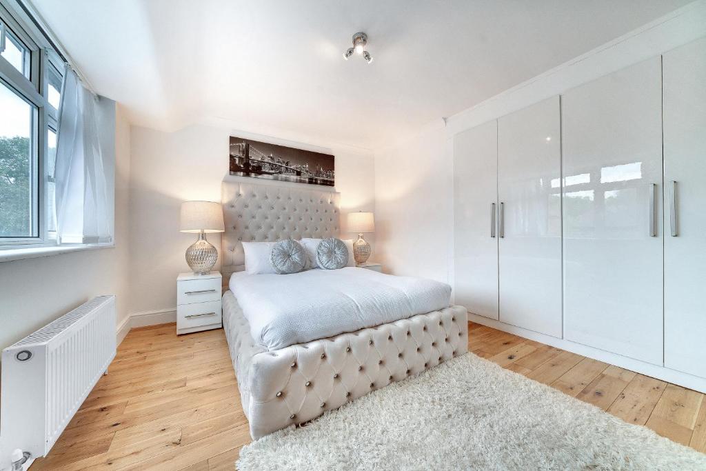 - une chambre blanche avec un lit et une fenêtre dans l'établissement Modern Deluxe 5 Bed 3 Bath House London Camberwell Denmark Private Parking, à Londres